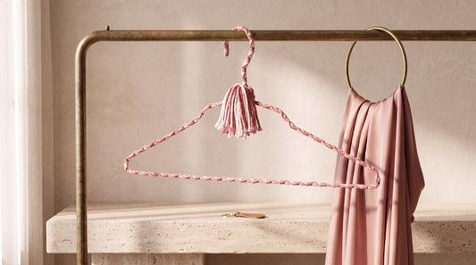 Blush Cameo rose-and-ivory hand-knotted cotton hanger in an elegant blush wardrobe setting