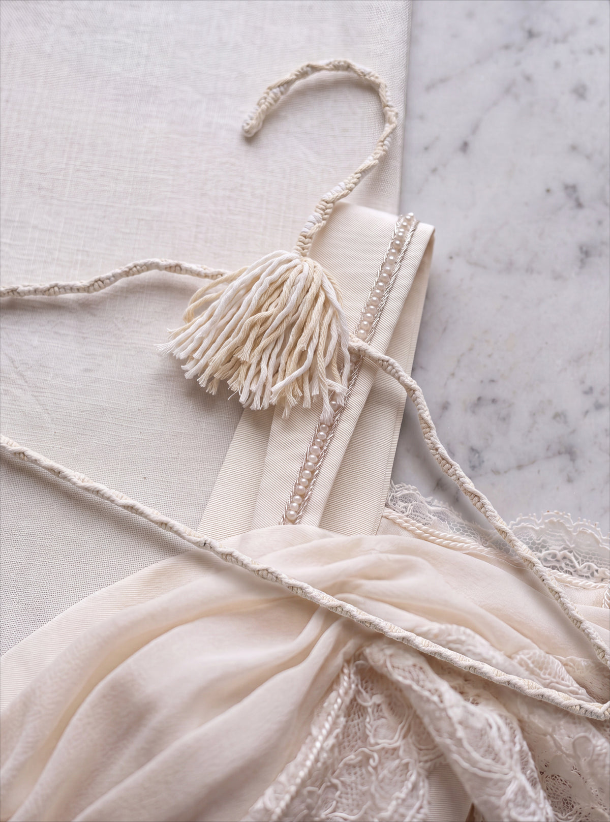 Bridal Veil soft ivory cotton hanger displayed on satin and lace
