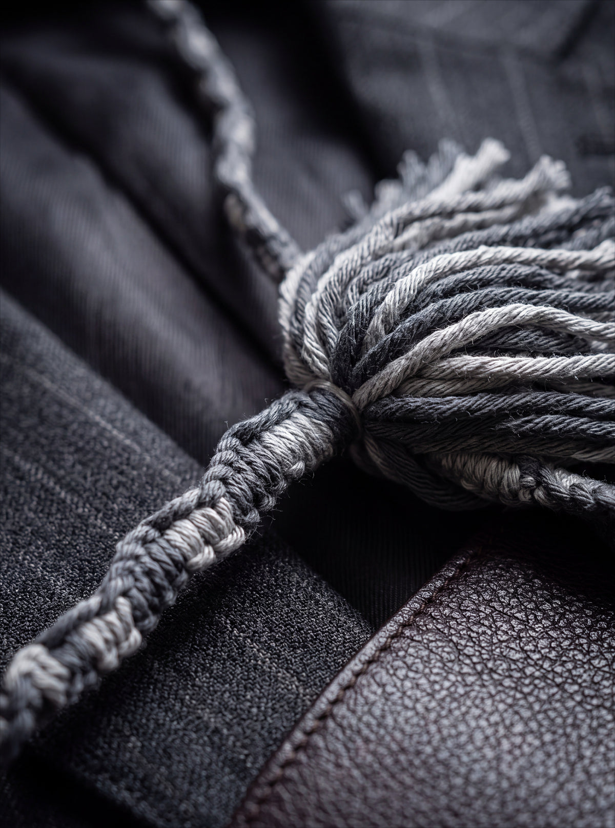 Close-up of Tailored Slate charcoal-and-gray hand-knotting on textured fabric